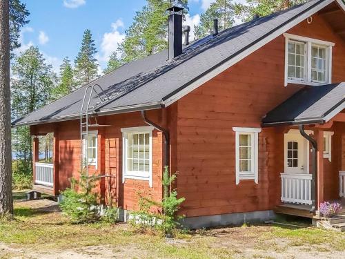 ein kleines rotes Haus mit weißen Fenstern in der Unterkunft Holiday Home Graniitti 3 by Interhome in Kinnula