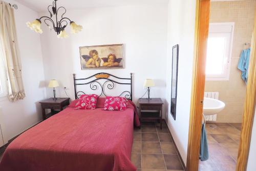 1 dormitorio con 1 cama con sábanas rojas y lavamanos en Casa Soleada en Arenas