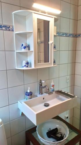 Jugendstil-Villa Aerö في Marstal: حمام مع حوض ومرآة