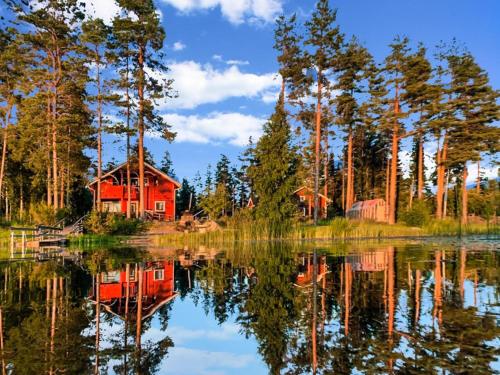 una cabina rossa sulla riva di un lago di Holiday Home Kallioniemi by Interhome a Toiviaiskylä
