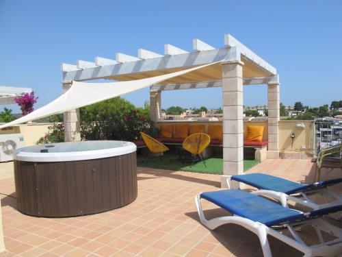 a gazebo with chairs and a hot tub on a patio at Apartment Penthouse Wohnung in Cala Romàntica