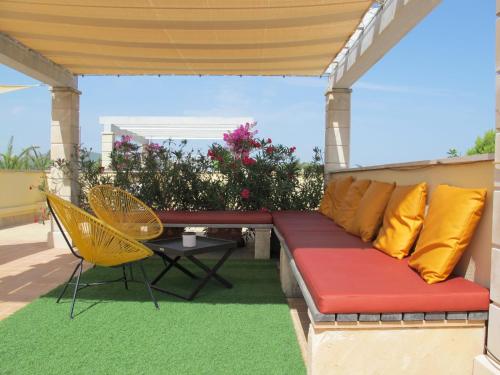 a couch on a patio with a table and chairs at Apartment Penthouse Wohnung in Cala Romàntica