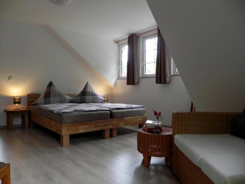 a bedroom with a bed and a couch and two windows at Ferienhaus Buschmuehle - Stolpen in Stolpen