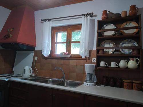 eine Küche mit einem Waschbecken und einem Fenster in der Unterkunft The old stone house in Paramythia
