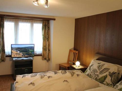 1 dormitorio con 1 cama y TV de pantalla plana en Apartment Alpentraum by Interhome en Saas-Grund
