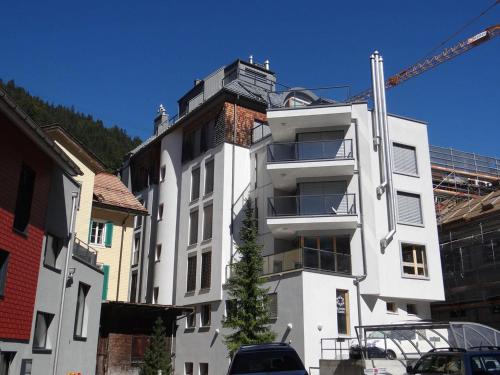 a white building with a crane in front of it at Apartment Dorfstrasse 7-42 by Interhome in Engelberg