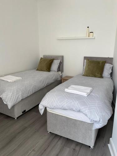 duas camas sentadas uma ao lado da outra num quarto em Union Street Apartment em Hawick