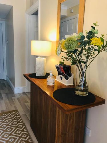 a vase of flowers on a table in a room at Apartment 101 Kingsmills Road in Inverness