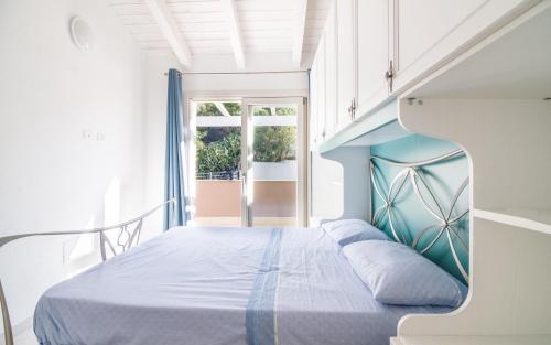1 dormitorio con 1 cama con cabecero azul en Villetta Massimo climatizzata con giardino privato, en Viddalba