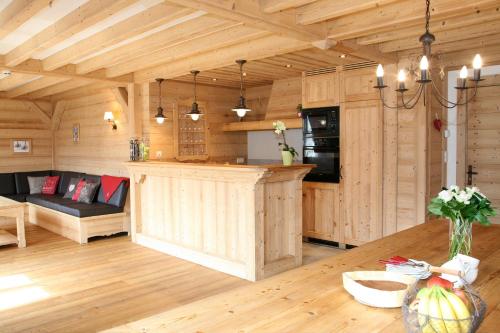 Il comprend une cuisine et un salon avec des murs en bois et une table. dans l'établissement Cordée Côté Sud, à Morzine