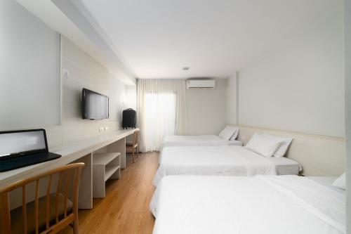 a hotel room with a bed and a desk at Rede Andrade Vernon in Curitiba