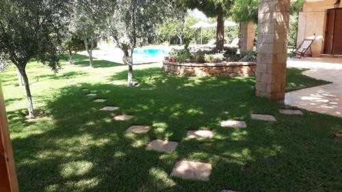 a garden with trees and rocks in a yard at MEDITERRANEAN GARDEN VILLA in Vathí