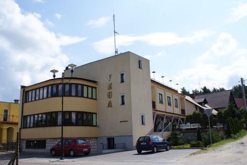 a building with two cars parked in front of it at Apartamenty Vega in Charzykowy