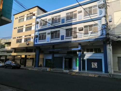 een blauw-wit gebouw aan de straatkant bij Hotel Pacífico in Guayaquil