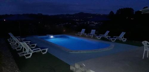 a swimming pool with lounge chairs and a pool at As Casinhas dos avós by Quinta do Paço in Amarante