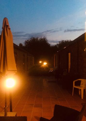 an umbrella and a light on a patio at night at Carpe Diem in Jumet