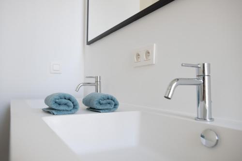 La salle de bains est pourvue de deux robinets et de deux serviettes. dans l'établissement Villa Beau Séjour, à Bruges
