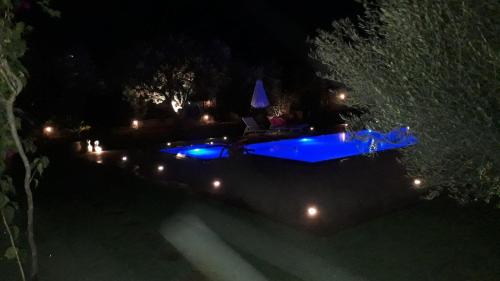 a blue boat in the water at night at MEDITERRANEAN GARDEN VILLA in Vathí