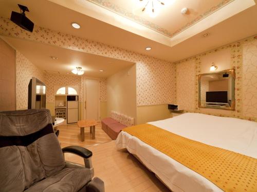 a hotel room with a bed and a chair at Hotel Fine Garden Matsuzaka II in Matsuzaka