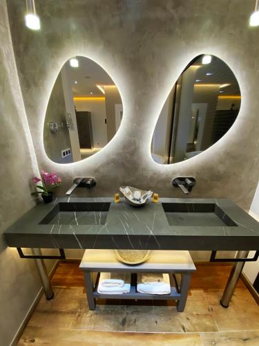 a bathroom with two sinks and two mirrors at Suite Rural Carenas in Carenas