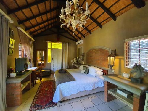 プレトリアにあるWaterhouse Guest Lodge in Waterkloofのベッドとシャンデリアのある寝室