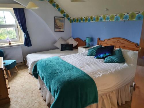 a bedroom with two beds with green pillows at The Goathland Hotel in Goathland