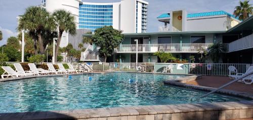 una gran piscina con sillas y un edificio en Clearwater Beach Hotel, en Clearwater Beach