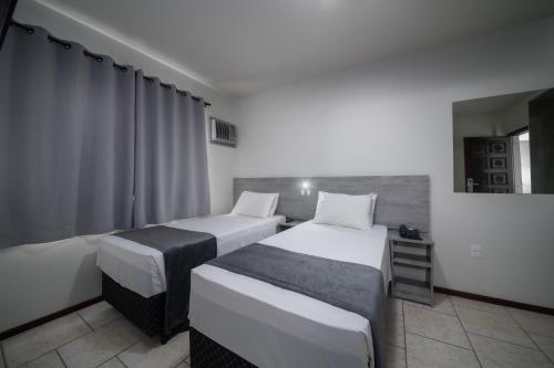 a hotel room with two beds and a window at Lumar Hotel in Florianópolis