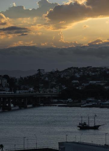 a boat in the water with a sunset in the background at Lumar Hotel in Florianópolis