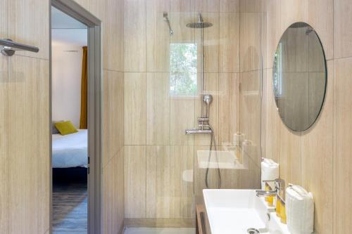ein Badezimmer mit Waschbecken und Spiegel in der Unterkunft SOWELL HOTELS L'Olivier in Arles