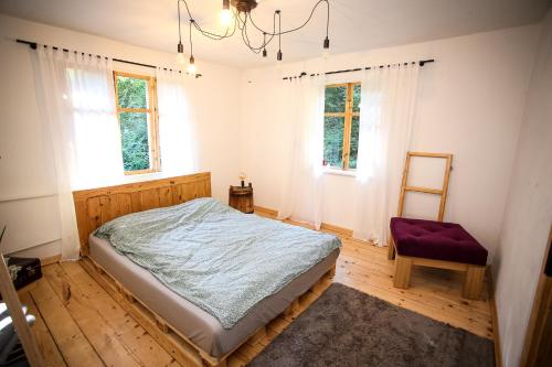 um quarto com uma cama, uma cadeira e janelas em 1950wisla Dom w górach em Wisla