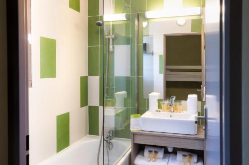 La salle de bains est pourvue d'un lavabo et d'une douche. dans l'établissement SOWELL Family Les Amandiers, à Arles