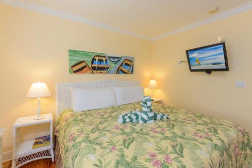 a bedroom with a bed and a tv on the wall at Key West Villas in Key West