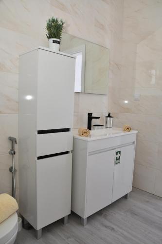 a white bathroom with a sink and a mirror at GuestReady - Sonho dos Avós II in Câmara de Lobos