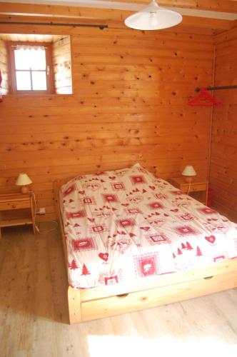 a bedroom with a bed in a log cabin at Maison de la Combe des Cives in Chapelle-des-Bois