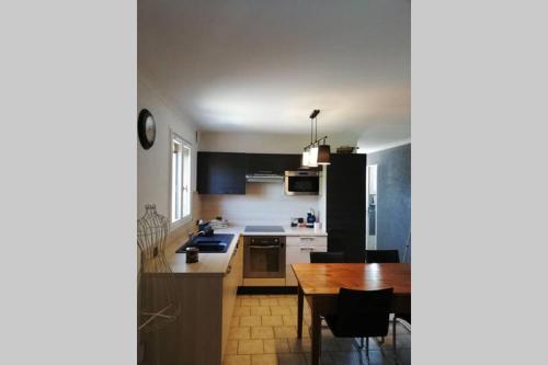 eine Küche mit Holztisch und ein Esszimmer in der Unterkunft Appartement à la nuitée in Marnaz