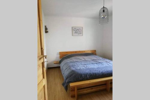 une chambre avec un lit avec une couette bleue dans l'établissement Appartement à la nuitée, à Marnaz
