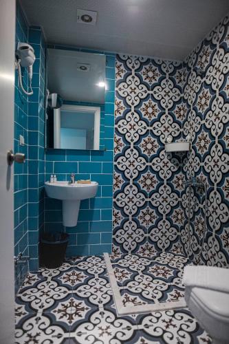 a bathroom with a sink and a blue tiled wall at Belsun Hotel in Beldibi