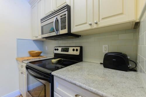 a kitchen with a stove and a microwave at Key West Villas in Key West