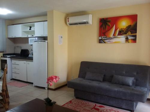 a living room with a couch and a kitchen at Solar Pipa Flats in Pipa