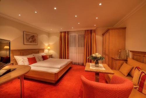 a hotel room with a bed and a table and chairs at Hotel Palin in Ischgl