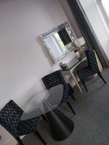 a dining room with chairs and a table with a mirror at Dean Park Hotel in Kirkcaldy