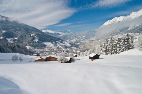 a snow covered mountain with a town in the distance at Huber Hotel Tramserhof in Landeck