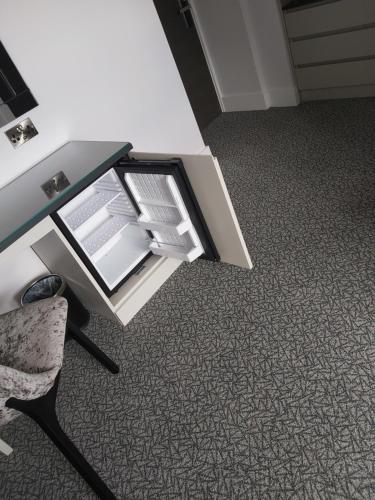 a desk with an open drawer and a chair at Dean Park Hotel in Kirkcaldy