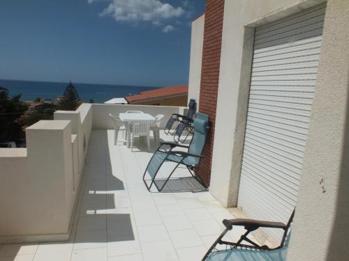 a balcony with chairs and tables on a building at Villa Isolde in Triscina