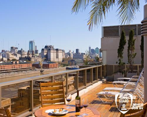 a balcony with tables and chairs and a view of the city at Hotel Madero Buenos Aires in Buenos Aires