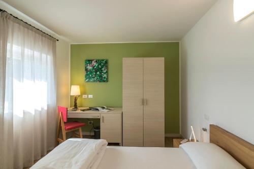1 dormitorio con 1 cama, escritorio y armario en Albergo Berna, en Erbezzo