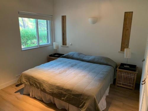 ein Schlafzimmer mit einem Bett und einem Fenster in der Unterkunft Villa Ponte Vista in Castro Marim