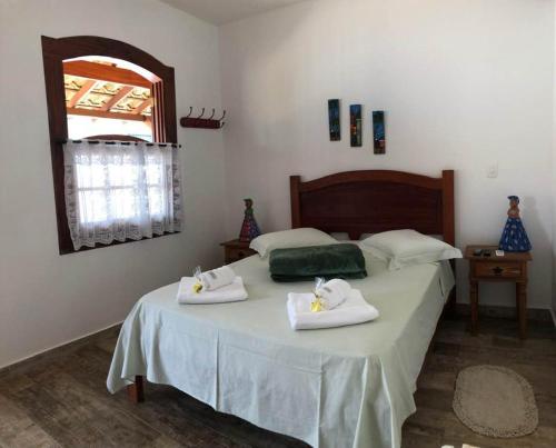 a bedroom with a bed with towels on it at Viva Brasil Pousada in Paraty