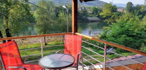 a balcony with a chair and a view of a river at Vikendica Pored Drine in Crvica